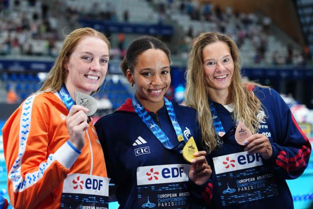 Gold medallist France's Mary-Ambre Moluh (C), silver medallist Netherlands' Marrit Steenbergen (L) and bronze medallist France's Pauline Mahieu (R) pose  on the podium of the women's 100m backstroke swimming event during the LEN European Aquatics Championships at the Olympic Aquatic Centre in Saint-Denis, northern suburbs of Paris, on August 15, 2026. (Photo by Dimitar DILKOFF / AFP)