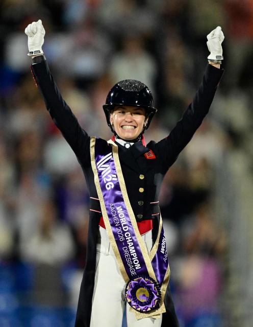 Winner Great Britain's Charlotte Fry celebrates on the podium of the Grand Prix Freestyle Individual Final of the FEI Dressage World Championship equestrian event on August 15, 2026 in Aachen, western Germany. (Photo by INA FASSBENDER / AFP)