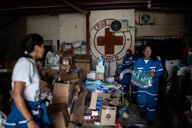 Members of the Red Cross organize aid for those affected by the earthquake in the Santo Domingo neighborhood of Quibdo, Choco department, Colombia, on August 15, 2026, days after a 7.4- magnitude earthquake. At least 287 people have died, thousands have been injured and about 379 remain unaccounted for, as the chances of finding earthquake survivors have dropped sharply since the critical 72-hour window passed, though volunteers and rescue crews continue digging through the rubble for any signs of life. (Photo by ESTEBAN VEGA LA-ROTTA / AFP)