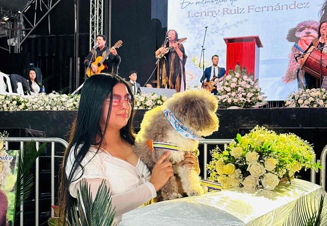 Jessica Florez, sister-in-law of the Colombian lawyer Lenny Ruiz, who died protecting her dog Salomon, during the August 10th earthquake in Cali, holds Solomon during Ruiz's funeral in Pasto, Colombia on August 13, 2026. (Photo by Eyder Portilla / AFP)