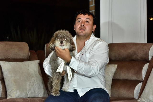 Michael Ruiz, brother of the Colombian lawyer Lenny Ruiz, who died protecting her dog Salomon, during the August 10th earthquake in Cali, holds Solomon in Pasto, Colombia on August 14, 2026. (Photo by Franklin  Ruiz / AFP)