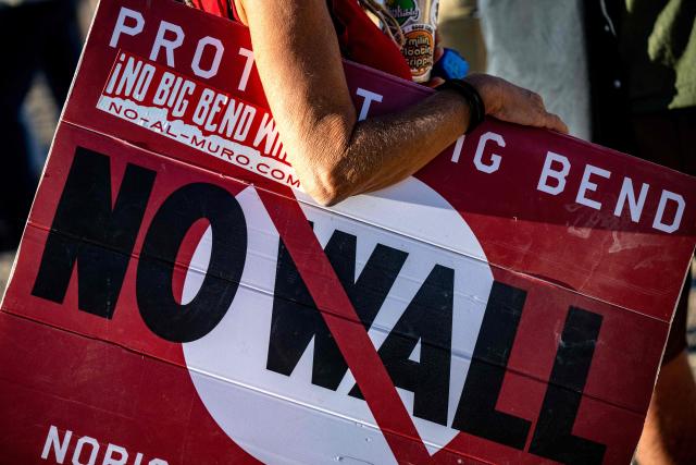 A woman hold's a sign to protest the plans by US President Donald Trump's administration to build a section of the border wall at the Big Bend National Park in Study Butte, Texas, on August 15, 2026. (Photo by RONALDO SCHEMIDT / AFP)