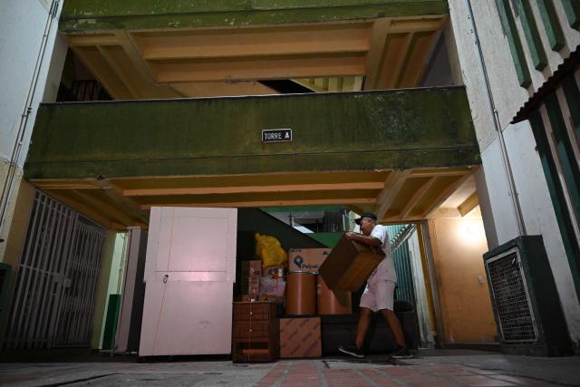 A man collects his belongings after a 7.4 earthquake in Cali, Colombia on August 15, 2026. At least 287 people have died, thousands have been injured and about 379 remain unaccounted for, as the chances of finding earthquake survivors have dropped sharply since the critical 72-hour window passed, though volunteers and rescue crews continue digging through the rubble for any signs of life. (Photo by Raul ARBOLEDA / AFP)