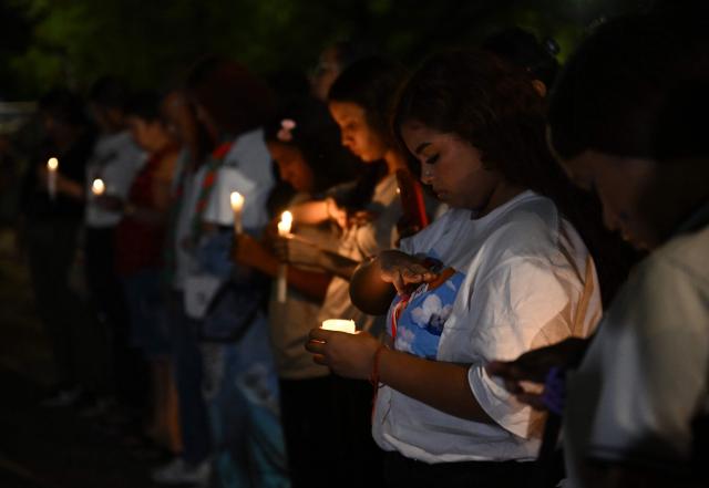 People hold candles during a vigil honouring the victims after a 7.4 earthquake in Cali, Colombia on August 15, 2026. At least 287 people have died, thousands have been injured and about 379 remain unaccounted for, as the chances of finding earthquake survivors have dropped sharply since the critical 72-hour window passed, though volunteers and rescue crews continue digging through the rubble for any signs of life. (Photo by Raul ARBOLEDA / AFP)
