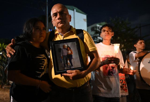 Carlos Zambrano holds a picture of his dissapeared brother during a vigil honouring the victims after a 7.4 earthquake in Cali, Colombia on August 15, 2026. At least 287 people have died, thousands have been injured and about 379 remain unaccounted for, as the chances of finding earthquake survivors have dropped sharply since the critical 72-hour window passed, though volunteers and rescue crews continue digging through the rubble for any signs of life. (Photo by Raul ARBOLEDA / AFP)