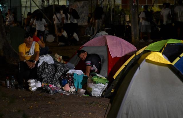 People spend the night on tents in a makeshift camp after a 7.4 earthquake in Cali, Colombia on August 15, 2026. At least 287 people have died, thousands have been injured and about 379 remain unaccounted for, as the chances of finding earthquake survivors have dropped sharply since the critical 72-hour window passed, though volunteers and rescue crews continue digging through the rubble for any signs of life. (Photo by Raul ARBOLEDA / AFP)