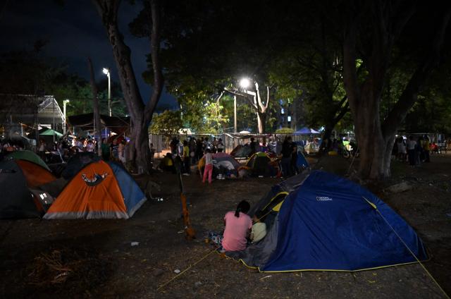 People spend the night on tents in a makeshift camp after a 7.4 earthquake in Cali, Colombia on August 15, 2026. At least 287 people have died, thousands have been injured and about 379 remain unaccounted for, as the chances of finding earthquake survivors have dropped sharply since the critical 72-hour window passed, though volunteers and rescue crews continue digging through the rubble for any signs of life. (Photo by Raul ARBOLEDA / AFP)