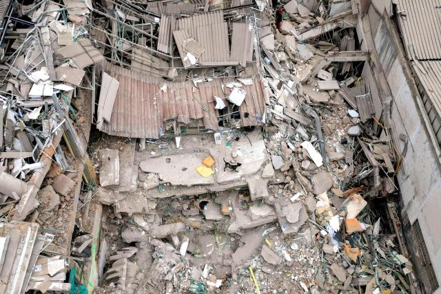 An aerial view shows a dog walking amid the rubble of a collapsed building after a 7.4 earthquake in Pereira, Colombia, on August 15, 2026. At least 287 people have died, thousands have been injured and about 379 remain unaccounted for, while the chances of finding earthquake survivors have dropped sharply since the critical 72-hour window passed. (Photo by Luis ACOSTA / AFP)