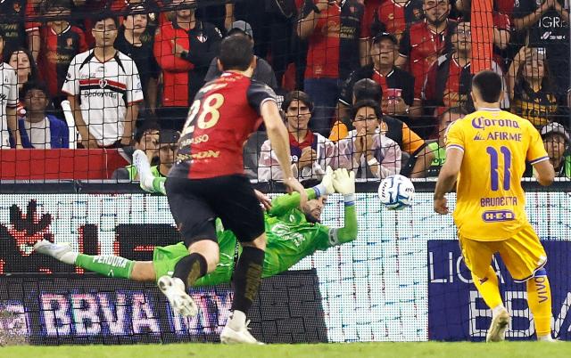 Atlas' Colombian goalkeeper #12 Camilo Vargas stops a penalty shoot by Tigres' Argentine midfielder #11 Juan Brunetta during the Liga MX Apertura tournament football match between Atlas and Tigres at Jalisco stadium in Guadalajara, state of Jalisco, Mexico on August 15, 2026. (Photo by ULISES RUIZ / AFP)
