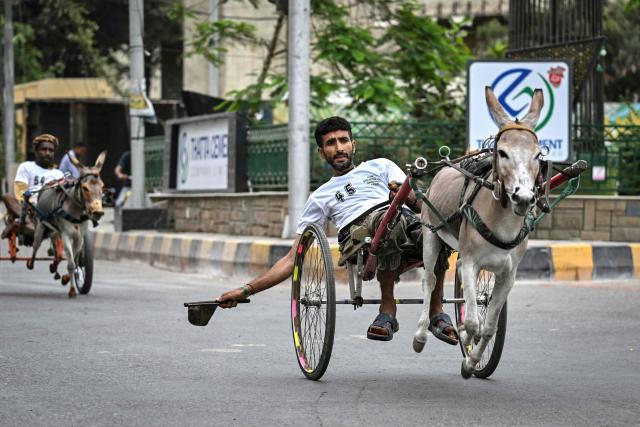 Participants compete in a donkey cart race organised by the local authorities in Karachi on August 16, 2026. (Photo by Asif HASSAN / AFP)