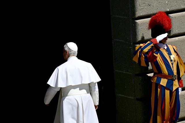 Pope Leo XIV walks past a Swiss Guard as he enters the Apostolic Palace in Piazza della Liberta (Liberty Square) at the end of the Angelus prayer in Castel Gandolfo, southeast of Rome on August 16, 2026. (Photo by Filippo MONTEFORTE / AFP)