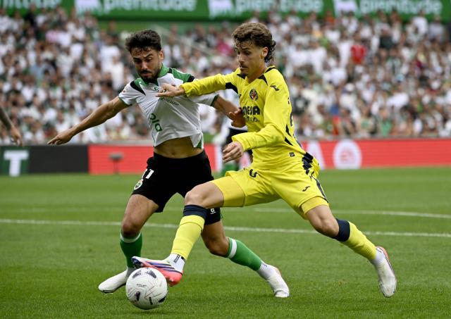 Racing Santander's Spanish forward #11 Andres Martin fights for the ball with Villarreal's Spanish defender #20 Carlos Romero during the Spanish league football match between Racing Santander and Villarreal in El Sardinero stadium in Santander on August 16, 2026. (Photo by ANDER GILLENEA / AFP)