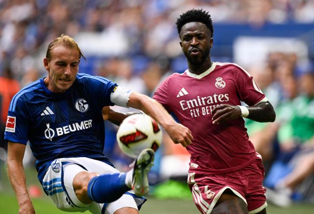 Schalke's German defender #05 Timo Becker (L) and Real Madrid's Brazilian forward #07 Vinicius Junior vie for the ball during the pre-season friendly football match between FC Schalke 04 and Real Madrid in Gelsenkirchen, western Germany, on August 16, 2026. (Photo by INA FASSBENDER / AFP)