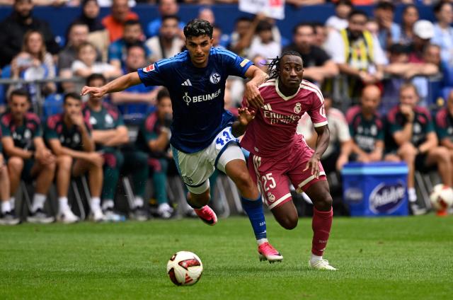 Schalke's Turkish defender #43 Mertcan Ayhan (L) and Real Madrid's Ivorian forward #25 Yan Diomande vie for the ball during the pre-season friendly football match between FC Schalke 04 and Real Madrid in Gelsenkirchen, western Germany, on August 16, 2026. (Photo by INA FASSBENDER / AFP)