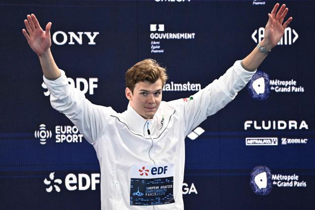 Hungary's Hubert Kos celebrates winning the gold medal on the podium of the men's 200m individual medley swimming event during the LEN European Aquatics Championships at the Olympic Aquatic Centre in Saint-Denis, northern suburbs of Paris, on August 16, 2026. (Photo by JULIEN DE ROSA / AFP)