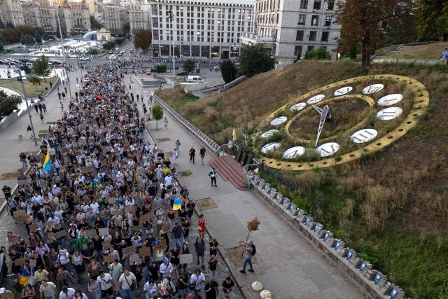 Protesters carry placards as they march during a rally calling for a reform of the defence sector and the reinstatement of the young and tech-savvy defence minister Mykhailo Fedorov, who was sacked a mounth ago, in central Kyiv on August 16, 2026, amid the Russian invasion of Ukraine. Fedorov, 35, was appointed in January on a mandate to modernise and digitise the Ukrainian military but was removed after months of behind-the-scenes clashes with the army command, who he said resisted his calls to change. His removal triggered a wave of protests that pushed President Volodymyr Zelensky to also replace army’s commander Oleksandr Syrsky, seen as Fedorov’s rival. (Photo by Serhii Okunev / AFP)
