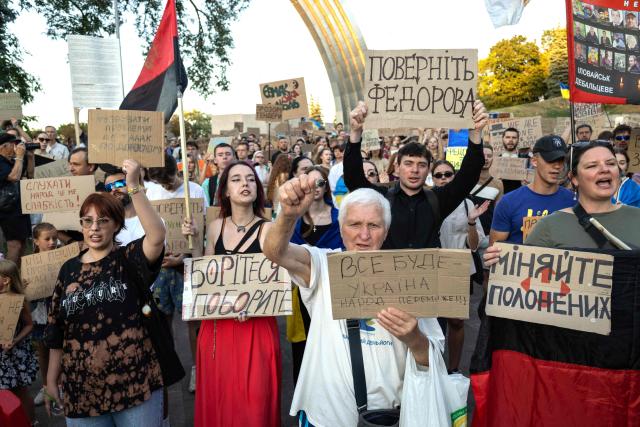 Protesters carry placards as they march during a rally calling for a reform of the defence sector and the reinstatement of the young and tech-savvy defence minister Mykhailo Fedorov, who was sacked a mounth ago, in central Kyiv on August 16, 2026, amid the Russian invasion of Ukraine. Fedorov, 35, was appointed in January on a mandate to modernise and digitise the Ukrainian military but was removed after months of behind-the-scenes clashes with the army command, who he said resisted his calls to change. His removal triggered a wave of protests that pushed President Volodymyr Zelensky to also replace army’s commander Oleksandr Syrsky, seen as Fedorov’s rival. (Photo by Serhii Okunev / AFP)