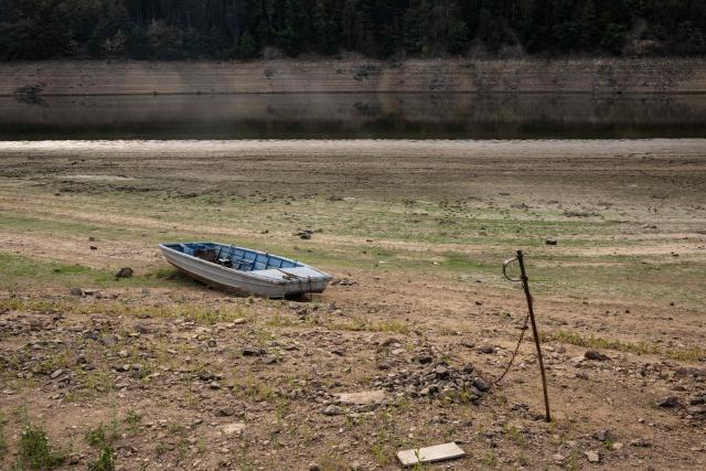 A boat sits on the bank of water reservoir Orlík - part of the Vltava Moldau river  near Podolsko village on August 16, 2026 as water levels of the Vltava - Moldau river  have reached historic lows for almost last 65 years. (Photo by Michal Cizek / AFP)