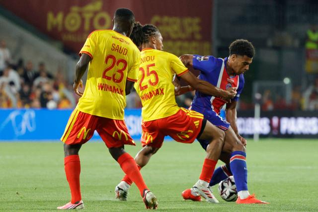 PSG's French forward #14 Desire Doue (R) fights for the ball with Lens' Saudi Arabian defender #23 Saud Abdulhamid (L) and Lens' French defender #25 Ismael Ganiouduring the French Super Cup (Trophee des Champions) football match between RC Lens and Paris Saint-Germain (PSG) at the Stade Bollaert-Delelis in Lens, northern France on August 16, 2026. (Photo by GEOFFROY VAN DER HASSELT / AFP)