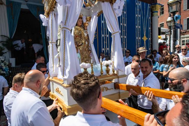 Members of the Maritime Society of the Madonna Del Soccorso Di Sciacca carry the statue of the Madonna del Soccorso di Sciacca as they march during a nine hour procession during the 116th Fisherman’s Feast Italian festival in Boston, Massachusetts on August 16, 2026. (Photo by JOSEPH PREZIOSO / AFP)