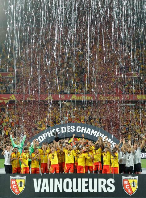 Lens' players celebrate with the championship trophy after winning the French Super Cup (Trophee des Champions) football match between RC Lens and Paris Saint-Germain (PSG) at the Stade Bollaert-Delelis in Lens, northern France on August 16, 2026. (Photo by GEOFFROY VAN DER HASSELT / AFP)