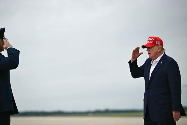 US President Donald Trump salutes as he steps off Air Force One upon arrival at Joint Base Andrews in Maryland on August 16, 2026. President Trump is returning to Washington, DC, after spending the weekend at his golf club in New Jersey. (Photo by Kent NISHIMURA / AFP)