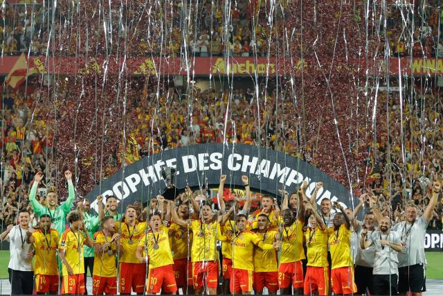 Lens' players celebrate with the championship trophy after winning the French Super Cup (Trophee des Champions) football match between RC Lens and Paris Saint-Germain (PSG) at the Stade Bollaert-Delelis in Lens, northern France on August 16, 2026. (Photo by GEOFFROY VAN DER HASSELT / AFP)