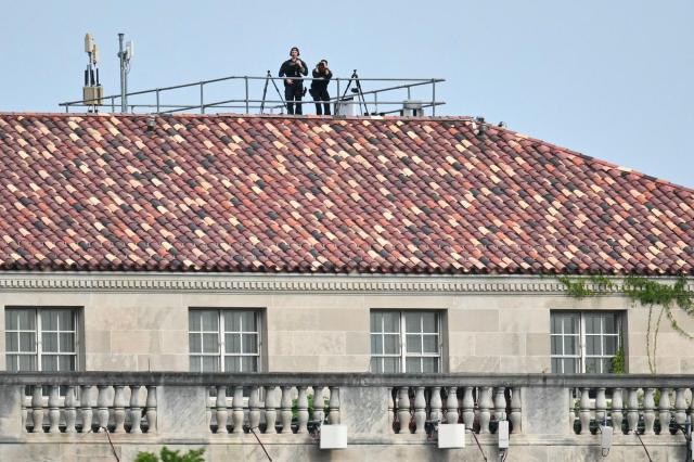 Members of the US Secret Service stand watch on a nearby roof ahead of US President Donald Trump's arrival on Marine One on the Ellipse near the White House on August 16, 2026. President Trump is returning to Washington, DC, after spending the weekend at his golf club in New Jersey. (Photo by Mandel NGAN / AFP)
