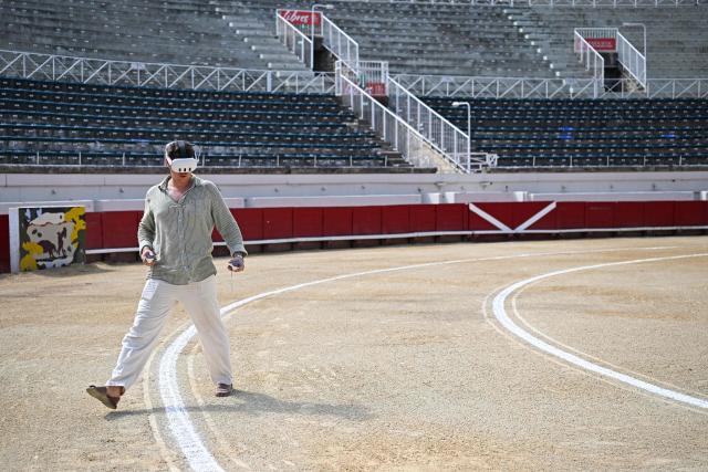 French artist Quentin Revilla uses a virtual reality headset to decorate the bullring ahead of a bullfight as part of the Feria in Beziers, southern France, on August 16, 2026. (Photo by Gabriel BOUYS / AFP)