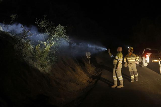 Firefighters of INFOAR Aragon forest fire prevention patrol around the San Juan de la Pena Monastery in Penas de Riglos, in the Spanish northeastern province of Aragon amid a wildfire that burnt 16,600 hectares, in the night of August 16, 2026. A Spanish soldier died on August 16, 2026 while helping efforts to extinguish a major wildfire in the northeastern region of Aragon that has raged for a week and threatened a 1,000-year-old monastery. Regional authorities said more than 16,600 hectares had been affected and around 1,000 people evacuated from various small settlements and villages. (Photo by Oscar DEL POZO / AFP)