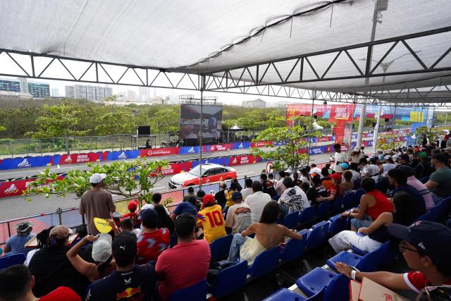 Patrons attend a racing event with Colombian Formula 1 driver Juan Pablo Montoya and his son Sebastian, which profit will be donated to the recent 7.4 earthquake victims, on a street circuit in Barranquilla, Colombia on August 16, 2026. At least 287 people have died, thousands have been injured and about 379 remain unaccounted for, as the chances of finding earthquake survivors have dropped sharply since the critical 72-hour window passed, though volunteers and rescue crews continue digging through the rubble for any signs of life. (Photo by Vanexa Romero / AFP)