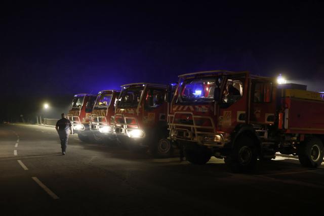 French firefighters from Perpignan unit prepare to battle fire in Santa Cruz de la Seros in the Spanish northeastern province of Aragon, in the night of August 16-17, 2026 amid a wildfire that burnt 16,600 hectares. A Spanish soldier died on August 16, 2026 while helping efforts to extinguish a major wildfire in the northeastern region of Aragon that has raged for a week and threatened a 1,000-year-old monastery. The regional government had announced what it called the largest firefighting deployment in Aragon's history to tame the blaze, with the arrival of 100 French reinforcements taking the total to 1,000 people. (Photo by Oscar DEL POZO / AFP)