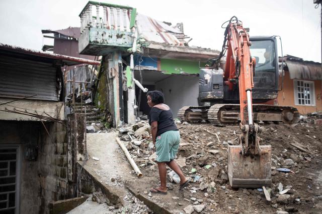 A woman walks next to a destroyed house after a 7.4 earthquake in Quibdo, Colombia on August 16, 2026. At least 287 people have died, thousands have been injured and about 379 remain unaccounted for, as the chances of finding earthquake survivors have dropped sharply since the critical 72-hour window passed, though volunteers and rescue crews continue digging through the rubble for any signs of life. (Photo by ESTEBAN VEGA LA-ROTTA / AFP)