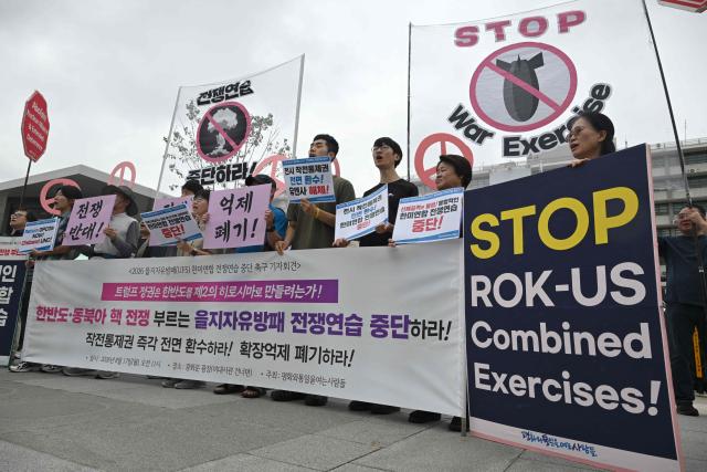 South Korean protesters hold placards as they attend a rally to oppose the joint military exercise between South Korea and the US named Ulchi Freedom Shield (UFS), in front of the US embassy in Seoul on August 17, 2026. South Korea's defence ministry said on August 17, that its joint military exercise with the United States has started after President Donald Trump's announcement it would be scaled back. (Photo by Jung Yeon-je / AFP)