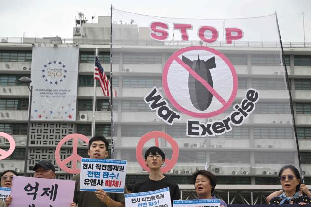 South Korean protesters hold placards as they attend a rally to oppose the joint military exercise between South Korea and the US named Ulchi Freedom Shield (UFS), in front of the US embassy in Seoul on August 17, 2026. South Korea's defence ministry said on August 17, that its joint military exercise with the United States has started after President Donald Trump's announcement it would be scaled back. (Photo by Jung Yeon-je / AFP)