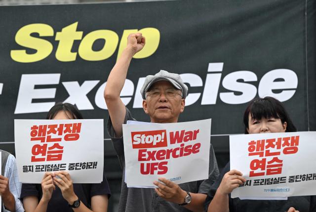 South Korean protesters hold placards as they attend a rally to oppose the joint military exercise between South Korea and the US named Ulchi Freedom Shield (UFS), in front of the US embassy in Seoul on August 17, 2026. South Korea's defence ministry said on August 17, that its joint military exercise with the United States has started after President Donald Trump's announcement it would be scaled back. (Photo by Jung Yeon-je / AFP)