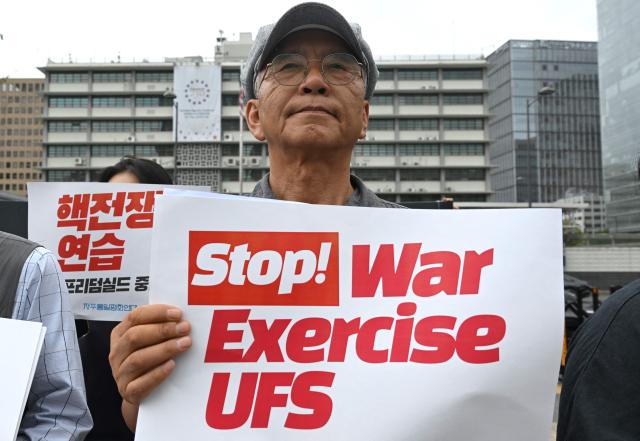 South Korean protesters hold placards as they attend a rally to oppose the joint military exercise between South Korea and the US named Ulchi Freedom Shield (UFS), in front of the US embassy in Seoul on August 17, 2026. South Korea's defence ministry said on August 17, that its joint military exercise with the United States has started after President Donald Trump's announcement it would be scaled back. (Photo by Jung Yeon-je / AFP)