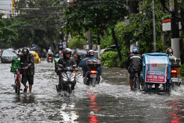 Motorists commute through a flooded street due to the rains brought by the southwest monsoon in Manila on August 17, 2026. (Photo by Jam STA ROSA / AFP)