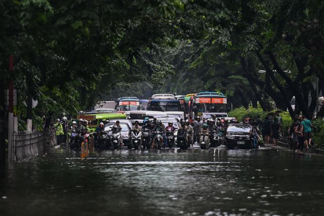 Motorists are seen stuck in traffic on a flooded street due to the rains brought by the southwest monsoon in Manila on August 17, 2026. (Photo by Jam STA ROSA / AFP)