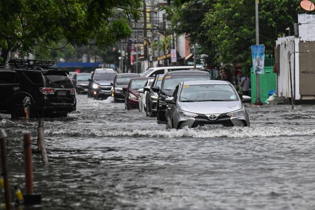 Motorists commute through a flooded street due to the rains brought by the southwest monsoon in Manila on August 17, 2026. (Photo by Jam STA ROSA / AFP)