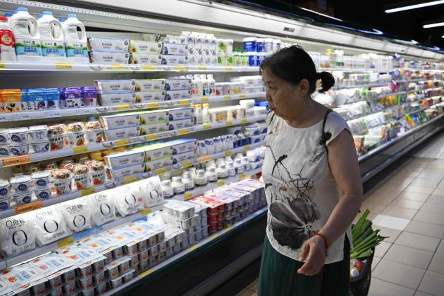 A customer looks at dairy products in a supermarket in Beijing on August 17, 2026. (Photo by Pedro PARDO / AFP)