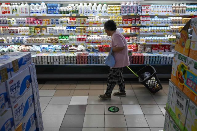 A customer looks at dairy products in a supermarket in Beijing on August 17, 2026. (Photo by Pedro PARDO / AFP)