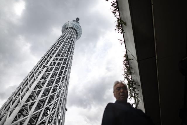 A man walks in front of the Tokyo Skytree in Tokyo on August 17, 2026. (Photo by Philip FONG / AFP)