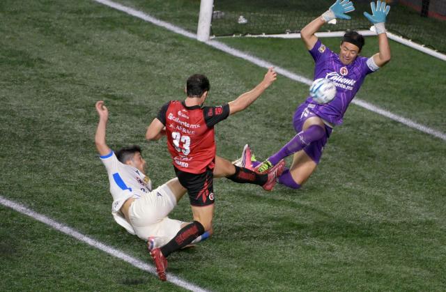 Cruz Azul's forward #07 Nicolas Ibanez (L), Tijuana's goalkeeper #02 Antonio Rodriguez and defender #33 Pablo Ortiz fight for the ball during the Liga MX Apertura football match between Tijuana and Cruz Azul at Caliente stadium in Tijuana, Mexico on August 16, 2026. (Photo by Guillermo Arias / AFP)