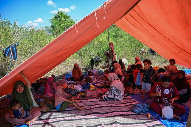 Villagers rest under a tent in an open field in Mbay, Nagekeo, East Nusa Tenggara, on August 17, 2026, following a 7.7-magnitude earthquake. Thousands of people displaced by a powerful earthquake in eastern Indonesia awaited much-needed aid on August 17 as they camped out at schools, police stations and government offices, with many stuck outside. (Photo by JUNI KRISWANTO / AFP)