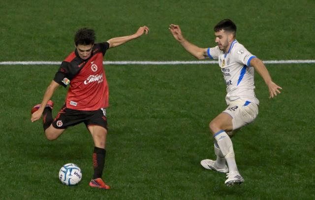 Tijuana's midfielder #10 Gilberto Mora shoots to score his team's second goal past Cruz Azul's defender #12 Alan Montes during the Liga MX Apertura football match between Tijuana and Cruz Azul at Caliente stadium in Tijuana, Mexico on August 16, 2026. (Photo by Guillermo Arias / AFP)