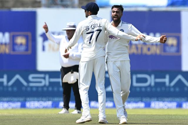 India's Manav Suthar (R) celebrates with captain Shubman Gill after taking the wicket of Sri Lanka's Dinesh Chandimal during the third day of the first Test cricket match between Sri Lanka and India at the Galle International Stadium in Galle on August 17, 2026. (Photo by Ishara S. KODIKARA / AFP)