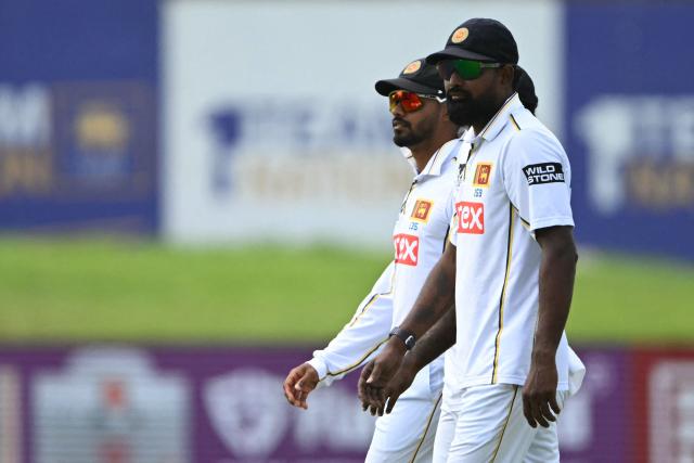 Sri Lanka's Prabath Jayasuriya (R) and captain Dhananjaya de Silva (L) look on during the third day of the first Test cricket match between Sri Lanka and India at the Galle International Stadium in Galle on August 17, 2026. (Photo by Ishara S. KODIKARA / AFP)