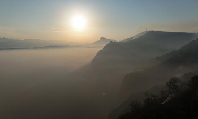 An aerial picture taken early on August 17, 2026 shows smoke and fog on the mountainsides near the San Juan de la Pena Monastery in Penas de Riglos in the Spanish northeastern province of Aragon amid a wildfire that burnt 16,600 hectares. A Spanish soldier died on August 16, 2026 while helping efforts to extinguish a major wildfire in the northeastern region of Aragon. The fire that has raged for a week threatened a 1,000-year-old monastery, sheltering the bones of the first Aragonese kings, founders of the Kingdom of Aragon. (Photo by Oscar DEL POZO / AFP)
