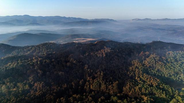 An aerial picture taken early on August 17, 2026 shows burnt forest on the mountainsides near the San Juan de la Pena Monastery in Penas de Riglos in the Spanish northeastern province of Aragon amid a wildfire that burnt 16,600 hectares. A Spanish soldier died on August 16, 2026 while helping efforts to extinguish a major wildfire in the northeastern region of Aragon. The fire that has raged for a week threatened a 1,000-year-old monastery, sheltering the bones of the first Aragonese kings, founders of the Kingdom of Aragon. (Photo by Oscar DEL POZO / AFP)